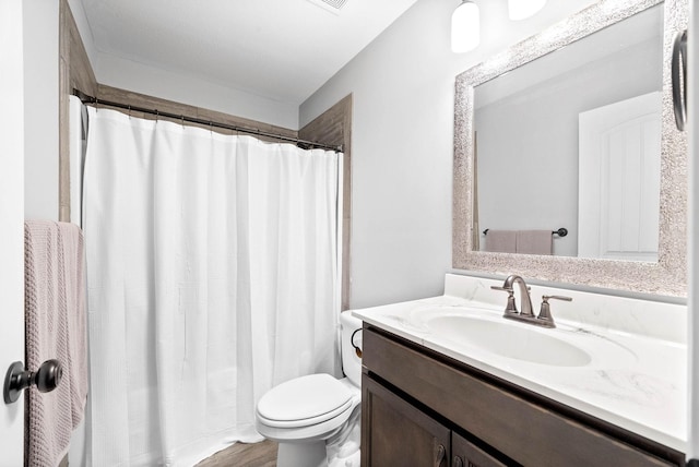 bathroom with wood-type flooring, vanity, and toilet