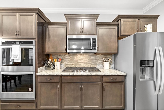 kitchen with appliances with stainless steel finishes, ornamental molding, light stone counters, and tasteful backsplash