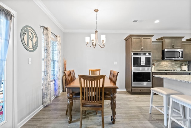 dining area with ornamental molding and a chandelier