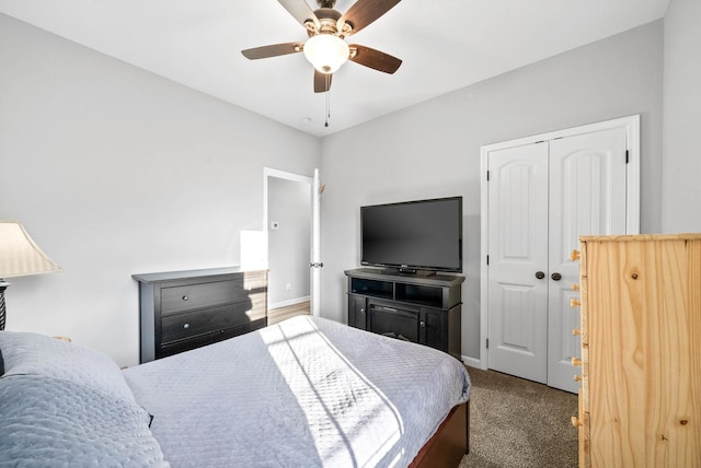 carpeted bedroom featuring ceiling fan and a closet