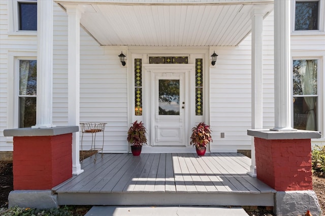 view of exterior entry featuring covered porch