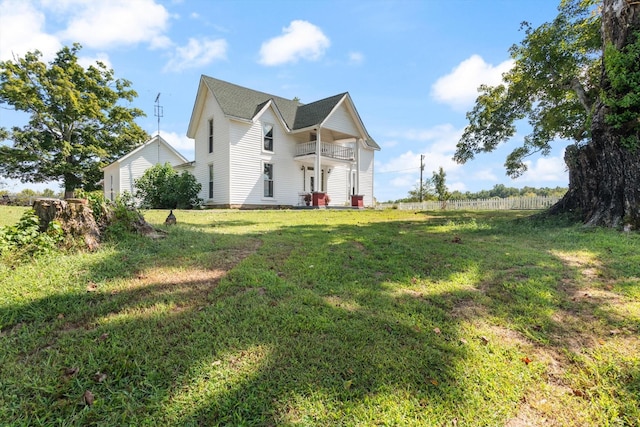 view of front of property with a balcony and a front lawn