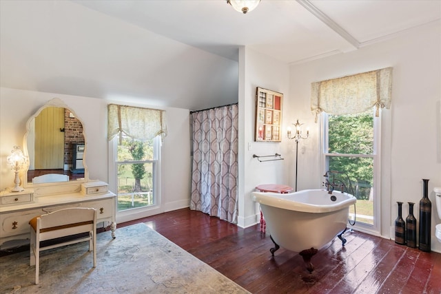 bathroom with hardwood / wood-style floors, a bathing tub, and beamed ceiling