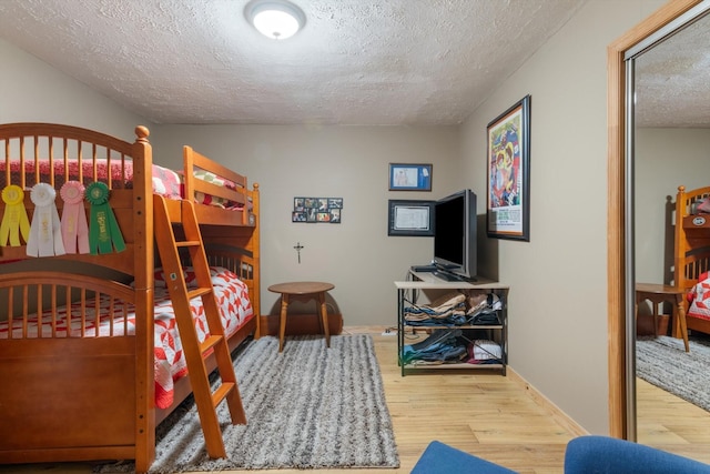 bedroom featuring wood-type flooring and a textured ceiling