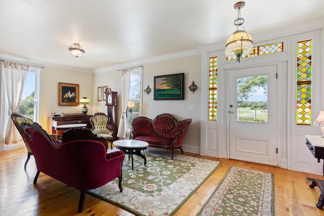 interior space featuring a notable chandelier, light wood-type flooring, and crown molding