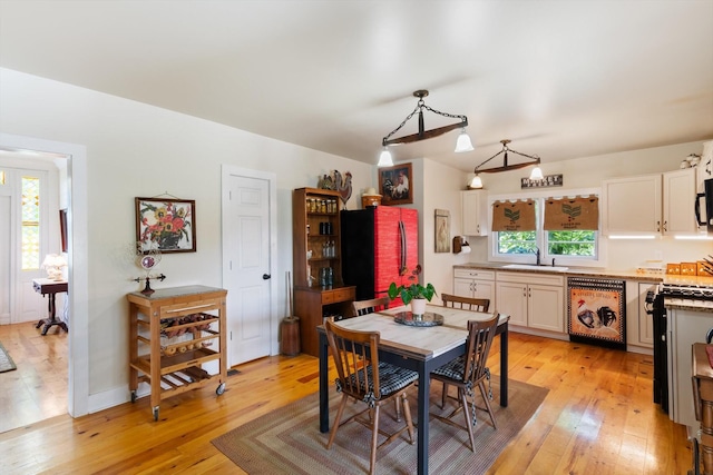 dining space with sink and light hardwood / wood-style floors