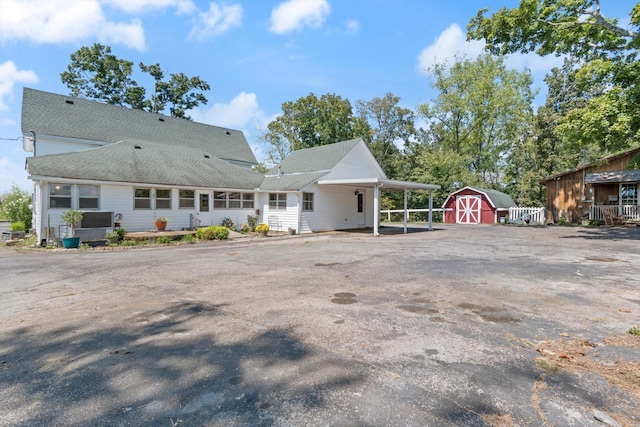 rear view of house featuring a shed and a carport