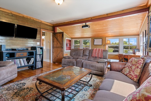 living room featuring wood walls, hardwood / wood-style flooring, vaulted ceiling with beams, a barn door, and wood ceiling