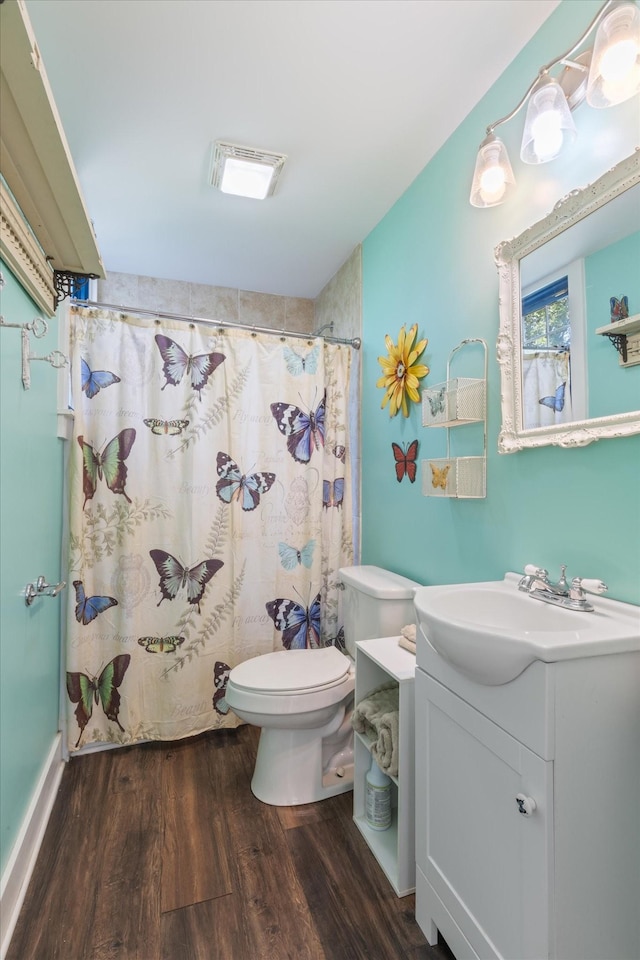 bathroom featuring curtained shower, hardwood / wood-style floors, vanity, and toilet