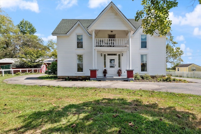 view of front facade featuring a balcony and a front yard