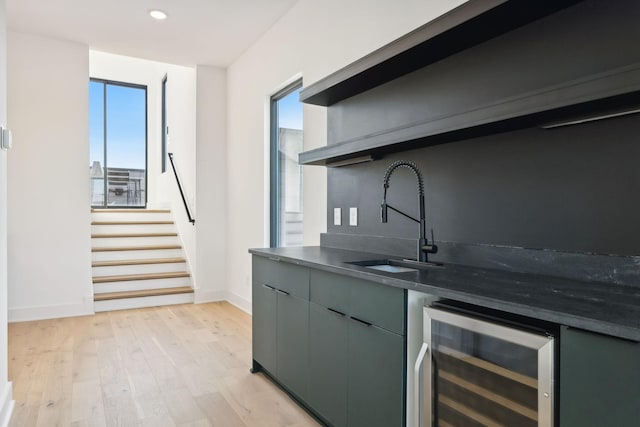 kitchen with decorative backsplash, light wood-type flooring, sink, and wine cooler