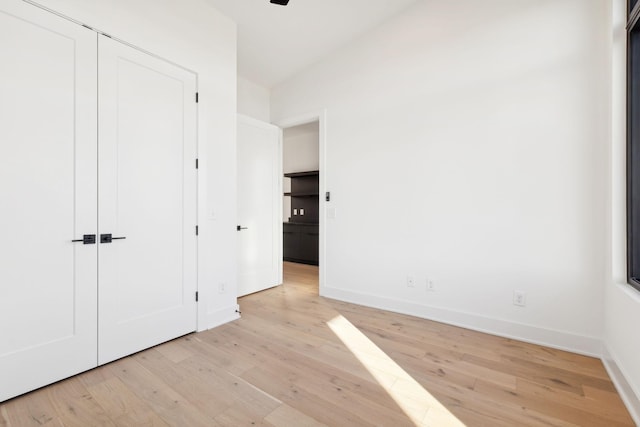 unfurnished bedroom featuring light hardwood / wood-style flooring and a closet