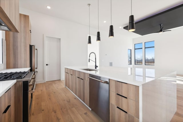 kitchen featuring decorative light fixtures, stainless steel appliances, ceiling fan, and sink