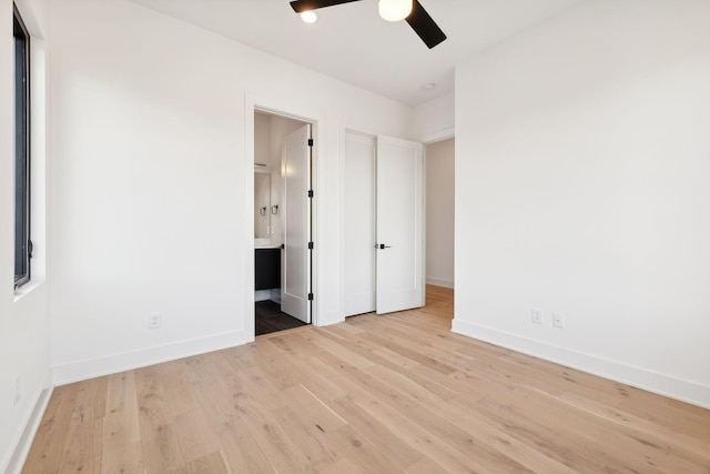 unfurnished bedroom with ensuite bathroom, ceiling fan, and light hardwood / wood-style flooring