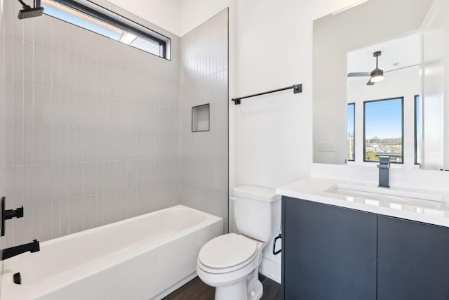 full bathroom with vanity, toilet, ceiling fan, and tiled shower / bath combo