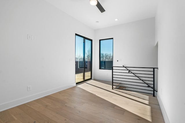 unfurnished room featuring plenty of natural light, ceiling fan, and light wood-type flooring