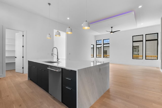 kitchen featuring stainless steel dishwasher, ceiling fan, sink, decorative light fixtures, and a large island