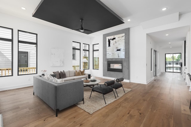 living room with a fireplace, hardwood / wood-style floors, and ceiling fan