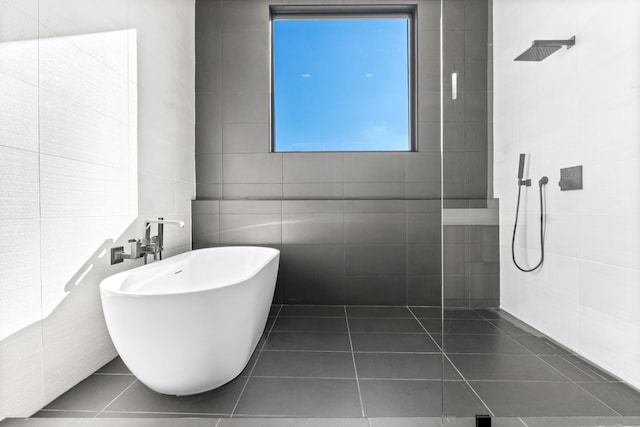 bathroom with tile patterned flooring, plus walk in shower, and tile walls