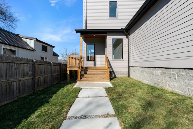 property entrance featuring a deck and a lawn