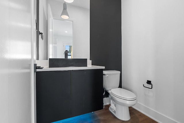 bathroom featuring wood-type flooring, vanity, and toilet