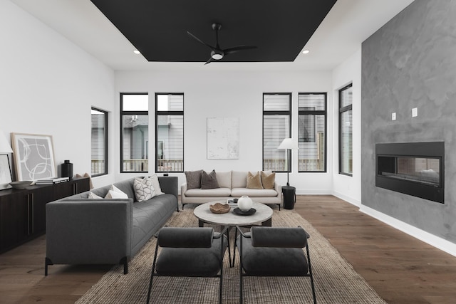 living room featuring a fireplace, dark hardwood / wood-style flooring, and ceiling fan