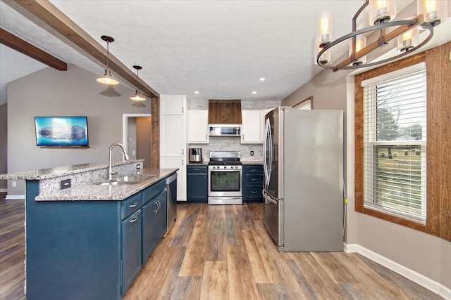 kitchen featuring stainless steel appliances, sink, blue cabinetry, decorative light fixtures, and white cabinets