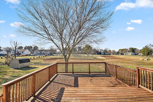 wooden terrace with a yard and a storage unit