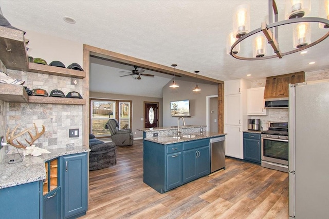 kitchen with tasteful backsplash, stainless steel appliances, blue cabinets, and ceiling fan