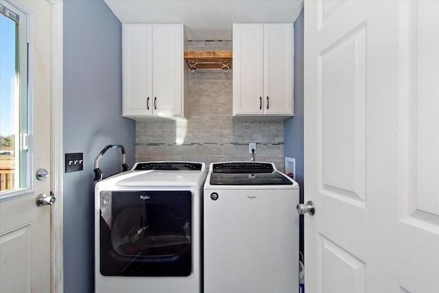 laundry room with separate washer and dryer and cabinets