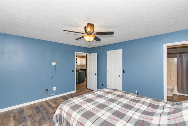 bedroom with a textured ceiling, ceiling fan, dark wood-type flooring, and connected bathroom