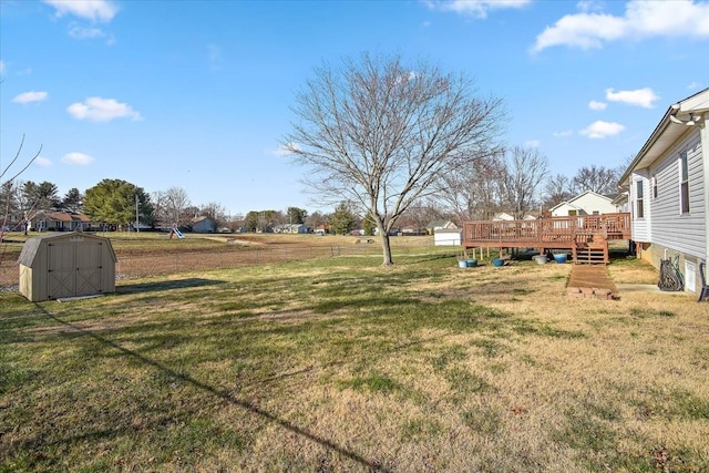 view of yard featuring a storage unit and a wooden deck