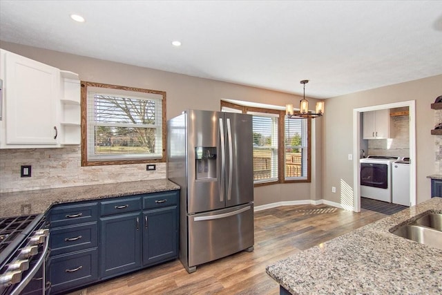 kitchen featuring tasteful backsplash, blue cabinets, washer / clothes dryer, white cabinets, and appliances with stainless steel finishes