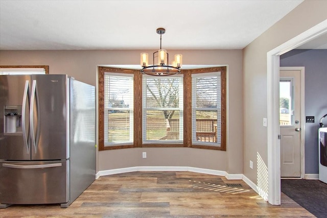 kitchen featuring a notable chandelier, wood-type flooring, stainless steel fridge with ice dispenser, and decorative light fixtures