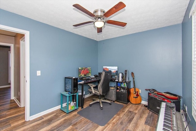 office area with a textured ceiling, ceiling fan, and dark hardwood / wood-style floors