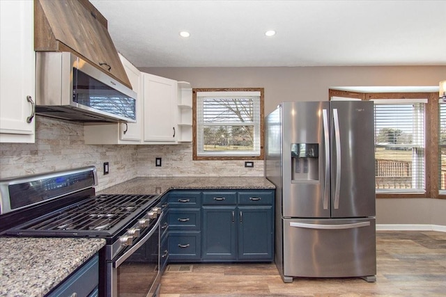 kitchen featuring light stone counters, white cabinetry, blue cabinets, and appliances with stainless steel finishes