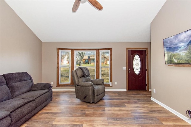 living room with hardwood / wood-style flooring, ceiling fan, and lofted ceiling