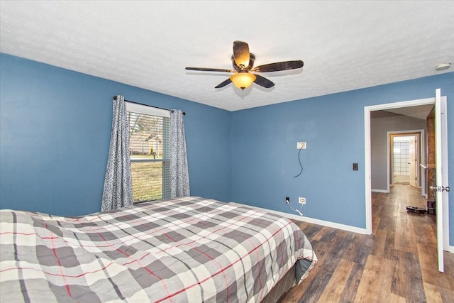 bedroom featuring ceiling fan, dark hardwood / wood-style flooring, and a textured ceiling