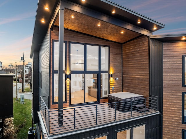 property exterior at dusk with a balcony and central air condition unit