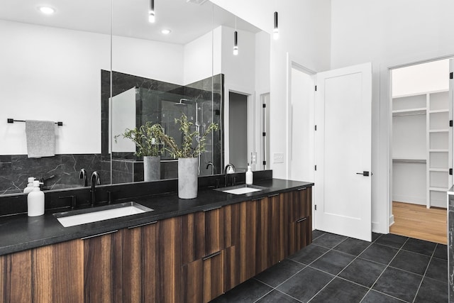 bathroom featuring a shower with shower door, vanity, and tile patterned flooring