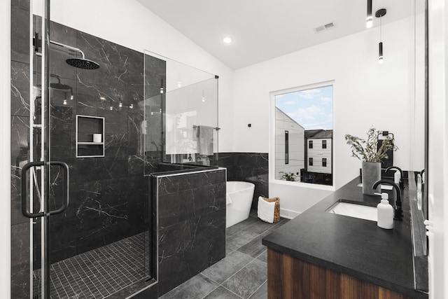 bathroom featuring tile patterned flooring, shower with separate bathtub, vanity, and vaulted ceiling