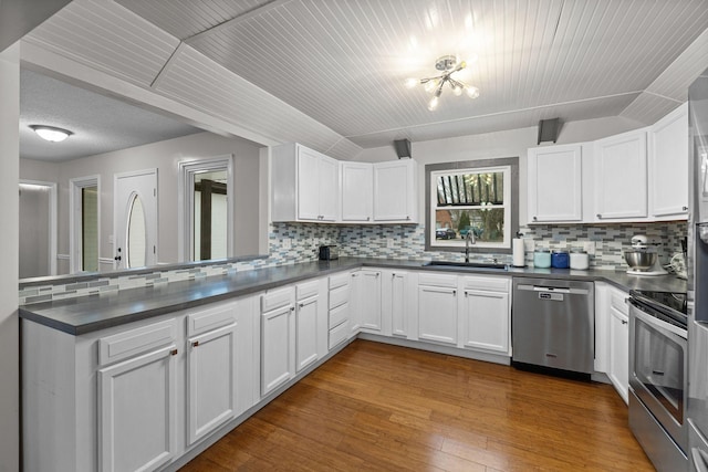 kitchen with decorative backsplash, appliances with stainless steel finishes, white cabinetry, and sink