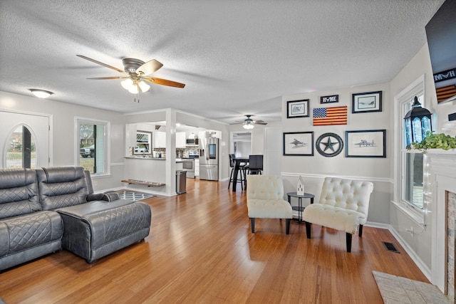 living room featuring a wealth of natural light, ceiling fan, and light hardwood / wood-style floors