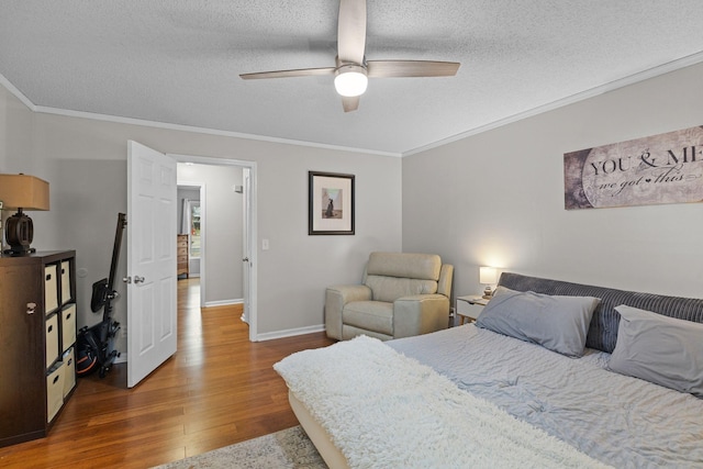 bedroom with hardwood / wood-style floors, ceiling fan, ornamental molding, and a textured ceiling