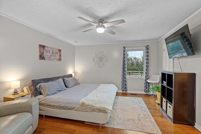 bedroom with hardwood / wood-style floors, ceiling fan, and crown molding