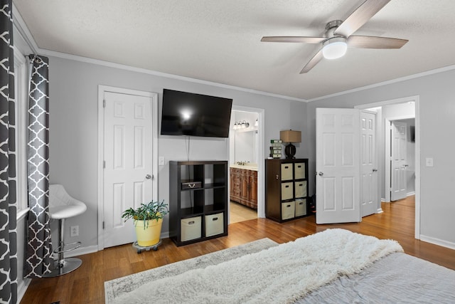 bedroom featuring hardwood / wood-style floors, connected bathroom, ceiling fan, and ornamental molding