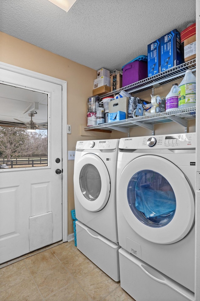 laundry area featuring light tile patterned floors, washer and dryer, and a textured ceiling