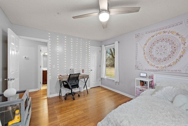 bedroom featuring ceiling fan, hardwood / wood-style floors, and a textured ceiling