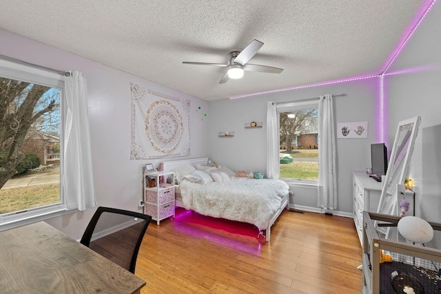 bedroom featuring ceiling fan, a textured ceiling, and light hardwood / wood-style flooring