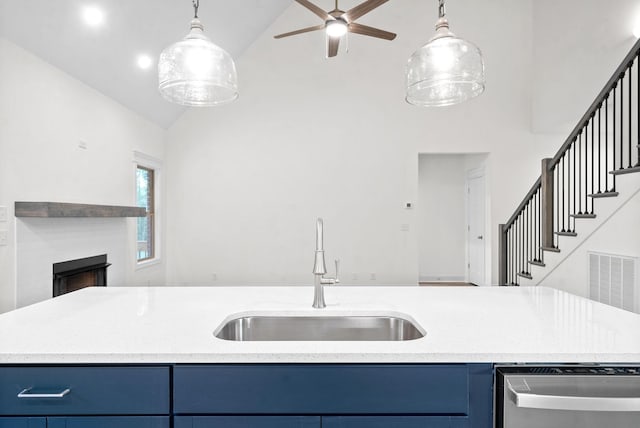 kitchen featuring vaulted ceiling, ceiling fan, sink, blue cabinetry, and dishwasher